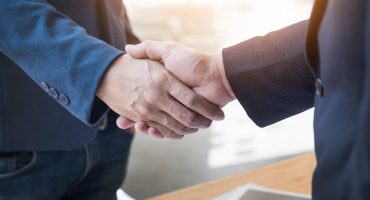 Two confident business man shaking hands during a meeting in the office, success, dealing, greeting and partner concept