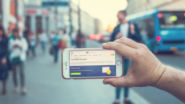 a person holding a white and gray smartphone